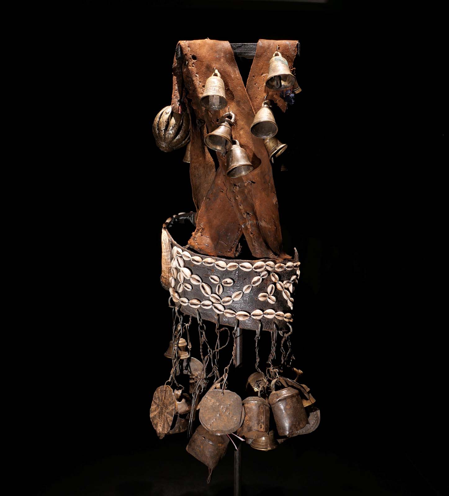 Glocken-Tanzgürtel eines Schamanen. Leder, Bronzeglocken, Kauri-Schnecken, Eisenglocken und Eisenscheiben. Frühes 20.Jhdt. Sehr selten.  Ost-Nepal 1200.- €. H 70 cm.